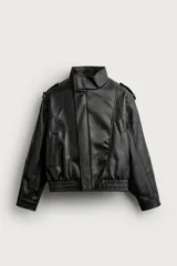 Cazadora biker relaxed fit confeccionada en tejido efecto piel, color negro. Cuenta con cuello subido, manga larga con puño ajustable y bajo elástico. Incluye bolsillos de vivo en la cadera y cierre frontal con cremallera oculta bajo una solapa diagonal con botones a presión.