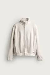 Chaqueta relaxed fit color beige melange, con cuello subido, manga larga y cierre frontal de cremallera. Cuenta con bolsillos de vivo en la cadera y acabados en rib.