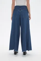 Pantalon de jean azul de corte ancho y tiro alto, con ruedo deshilachado.