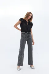 Pantalón de jean gris con efecto lavado, corte recto, tiro alto y bolsillos delanteros con alforza central.