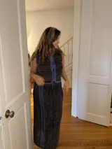 Falda larga tejida con diseño calado, color camel con detalles de rayas en contraste color azul. Presenta tajos laterales y cintura elástica.