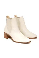 Botines tipo Chelsea de cuero color off-white, con paneles laterales elásticos a tono, punta ligeramente cuadrada y tacón de bloque de madera.