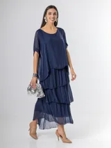 Vestido largo azul marino de seda italiana, con diseño de volados escalonados en la falda y una sobrecapa superior con mangas cortas amplias.