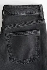 Jean tobillero de cinco bolsillos en denim con leve stretch, de pierna recta, cintura de tiro alto y cierre con botón. Presenta un corte ajustado desde la cadera hasta el muslo, con un diseño ligeramente más ceñido en el bajo.