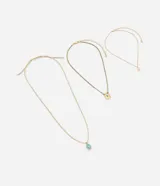 Collar de bisutería en capas compuesto por tres cadenas doradas con dijes colgantes, incluyendo una medalla con detalle floral, un dije ovalado con esmalte turquesa y corazón, y un cordón trenzado multicolor con un dije rectangular con piedra turquesa.