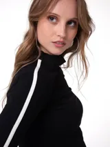 Remera de manga larga color negro con cuello alto, ajuste ceñido al cuerpo y detalle de raya blanca lateral en las mangas. Cuenta con aberturas para el pulgar en los puños.