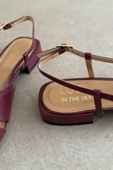 Sandalias de cuero bordó con taco bajo, tiras cruzadas en el empeine y tira ajustable con hebilla en el talón.