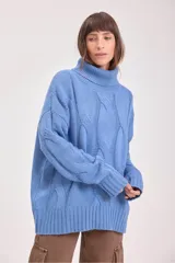 Sweater de punto color azul, con cuello alto y diseño de trenzas verticales. Presenta mangas largas con puños acanalados y un corte holgado.
