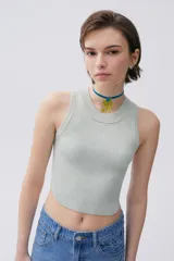 Top tejido color verde claro, de corte cropped y cuello redondo.