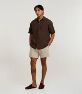 Bermuda playera masculina de corte básico, confeccionada en microfibra texturizada. Presenta cintura elástica con cordón ajustable y bolsillos laterales.