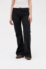 Jean de corte oxford en color negro, con ajuste en cintura y caderas, y piernas amplias. Presenta un diseño estructurado con cierre de botón y cremallera, y bolsillos clásicos.