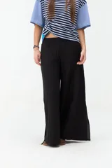 Pantalón negro de corte ancho y fluido, confeccionado en tejido ligero y cómodo, con cintura alta y diseño recto.