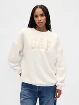 Buzo de corderito color blanco, con cuello redondo, mangas largas y logo de la marca bordado en el frente.