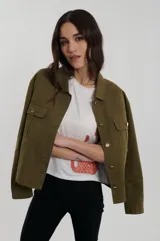 Campera de estilo utility con cuello camisero, cierre frontal de botones dorados y bolsillos de parche con solapa en el pecho.