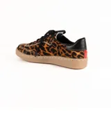 Zapatilla urbana de cuero con pelo estampado animal print de leopardo. Presenta cordones negros, detalle de cuero negro en el talón y suela cosida de goma en color tostado.