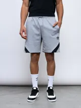 Bermuda deportiva negra de algodón y poliéster, con cintura elástica ajustable con cordón, bolsillos laterales y detalle de recortes geométricos en gris en los laterales. Logo de la marca bordado en la pierna izquierda.