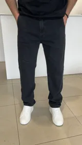 Jeans mom fit negro con efecto gastado, tiro medio y corte recto ligeramente holgado.