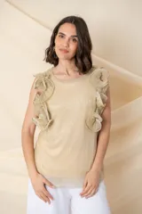 Blusa de gasa plisada con lurex, color dorado, con cuello redondo y detalle de volados armados en los hombros.