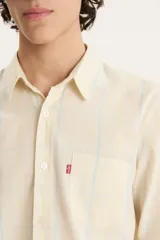 Camisa de manga larga a cuadros celestes y amarillos, con bolsillo en el pecho y logo rojo de la marca.