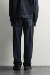 Pantalón jeans straight fit de tiro bajo, confeccionado en denim de algodón oscuro sin lavados, con diseño de pierna recta, cinco bolsillos y cierre frontal de botonadura.