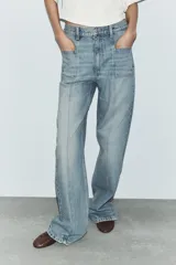 Jeans de tiro alto con corte recto, confeccionados en denim de lavado claro. Presentan bolsillos frontales tipo parche y costuras verticales decorativas en el frente.