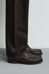 Zapato tipo náutico de piel marrón con acabado abatanado, pas Cordones del mismo tono, ojetes metálicos, plantilla de piel y suela track de goma.
