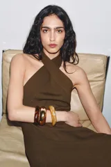 Pack de tres pulseras rígidas de diseño minimalista. Incluye dos brazaletes de resina con efecto carey en tonos marrón claro y oscuro, y un brazalete metálico de acabado dorado.