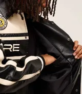 Campera masculina de cuero sintético, modelo boxy, con cuello inglés, manga larga, estampa lettering, detalles contrastantes, bolsillos y cierre por cremallera.