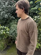 Sweater azul marino de lana con cuello redondo y logo bordado en rojo en el pecho. Corte holgado.