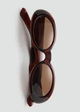 Gafas de sol con diseño ovalado y montura de pasta en tono rojizo oscuro. Cuentan con cristales marrones y protección UV categoría 3.