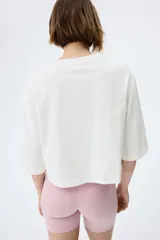 Remera oversized confeccionada en punto de algodón suave, de corte boxy con cuello redondo, hombros caídos y media manga.