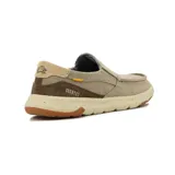 Zapato casual tipo slip-on de lona color kaki, con elásticos laterales, detalles en marrón y suela de goma con tecnología de amortiguación.