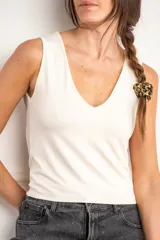 Musculosa color crudo, de poliéster y elastano, corte al cuerpo y escote en V.