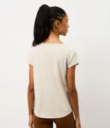 Remera deportiva de microfibra texturizada, color blanco, con cuello redondo, mangas cortas y recortes laterales.