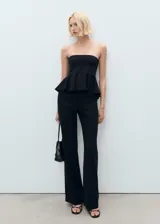 Top negro strapless con diseño peplum en la cintura, confeccionado con mezcla de viscosa, poliamida y elastano.