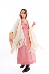 Ruana tejida en mezcla de lana y seda, color crudo, con diseño liviano y acabado de flecos largos en los bordes.