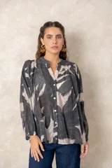 Camisa oversize con estampado abstracto en tonos marrones y beige, cuello mao y cierre frontal con botones. Presenta mangas largas anchas con puños abotonados y un corte holgado.