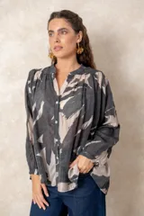 Camisa oversize con estampado abstracto en tonos marrones y beige, cuello mao y cierre frontal con botones. Presenta mangas largas anchas con puños abotonados y un corte holgado.