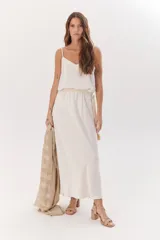 Falda larga color beige confeccionada en satén, de corte recto y cintura elastizada.