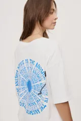 Remera de manga corta y cuello redondo, de corte oversized en color marrón, con texto bordado o estampado a lo largo del escote en el hombro izquierdo.