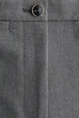 Pantalón sastrero de tiro alto con corte acampanado y pliegues frontales. Cuenta con cierre de botón y bolsillos decorativos.
