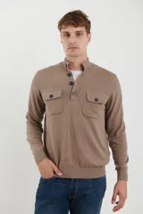 Remera manga larga color marrón claro, con cuello alto abotonado y dos bolsillos frontales con botón.
