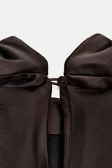 Vestido corto de tejido satinado color marrón chocolate, con cuello subido y lazada tipo foulard integrada. Presenta mangas largas amplias, detalle de frunces en la cintura y cierre lateral con cremallera oculta.