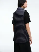 Chaleco acolchado de Save The Duck, con diseño de estructura horizontal, cuello alto y cierre frontal con botones a presión. Confeccionado en nylon ultraligero con relleno tecnológico que proporciona aislamiento térmico y protección contra el viento.