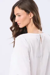 Blusa clásica de manga larga en color blanco, con cuello redondo y diseño fluido.