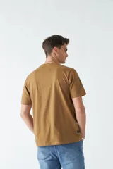 Remera color marrón con estampa de montañas, texto y coordenadas geográficas.