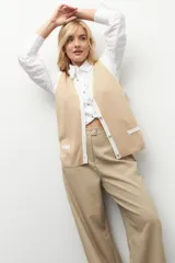 Pantalón sastrero ancho color verde oliva, de tiro alto, con pretina ancha de un botón, bolsillos laterales y pinzas en el frente.