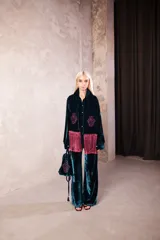 Cartera de mano tipo bolsa confeccionada en terciopelo de seda color violeta, con bordado floral en hilo dorado y detalle de borlas colgantes.