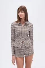 Camisa de viscosa a cuadros en tonos beige, marrón y blanco, con cuello camisero, cierre frontal y corte ajustado al cuerpo.