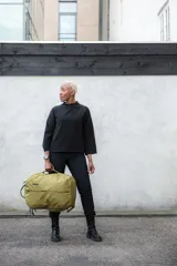 Mochila de viaje Thule Aion de 40 litros, color marrón, con diseño ergonómico y compartimento acolchado para laptop de hasta 17 pulgadas. Cuenta con bolsa enrollable extraíble de TPU, bolsillos organizadores internos y externos, y correas de compresión. Fabricada con tejido de lona encerada reciclada resistente al agua.